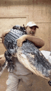 a man is holding a large alligator on his back