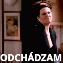 a woman is standing in front of a sign that says odchadom