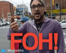 a man in a purple jacket is giving a thumbs up with the word foh in red