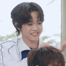 a young man wearing headphones looks at another young man 's hair