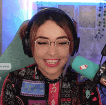 a woman wearing headphones and a shirt that says ' tl ' on it smiles