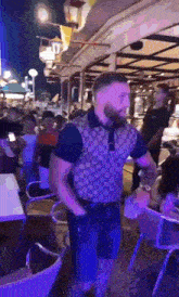 a man in a gucci shirt is dancing in a crowded bar .
