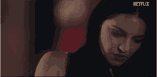 a close up of a woman 's face with a netflix logo in the background