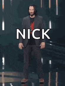 a man in a suit is standing in front of a sign that says nick you 're breathtaking !