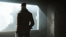 a man with a red hat looks out a window
