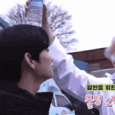 a man holds a bottle of water above his head