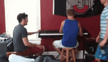 a group of men are playing a piano in front of a ohio state flag