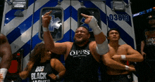 a group of wrestlers are standing in front of an ambulance with the number 03813