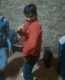 a man in a blue shirt is smoking a cigarette while a boy in a red shirt is dancing