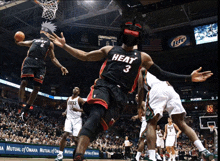 a basketball player wearing a heat jersey is being fouled