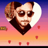 a man wearing sunglasses is in a heart shaped frame with the name khil below him