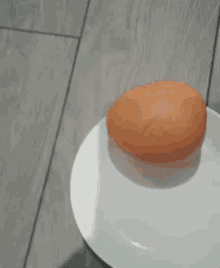 an orange is sitting on a white plate .