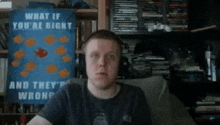 a man wearing headphones is sitting in front of a poster that says what if you 're right and they 're wrong