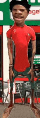 a man in a red shirt and green shorts stands in front of a sign that says age