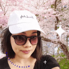 a woman wearing sunglasses and a white hat that says " phatworld "
