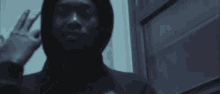 a man in a hooded sweatshirt is talking on a cell phone .