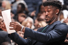 a man in a suit is holding a piece of paper