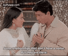 a man and a woman are standing next to each other and talking to each other .