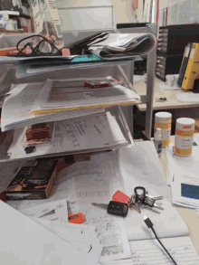a messy desk with papers and a box of coffee