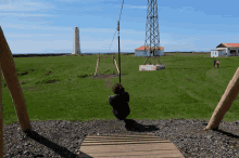 a person sitting on a zip line in a grassy field
