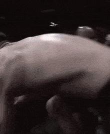 a man 's back is shown in a dark room