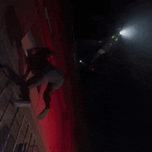 a person climbs up a ladder in the dark