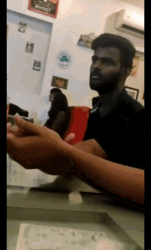 a man sitting at a table with a sign that says whiskey on the wall