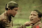 a man wearing a helmet is touching the neck of another man