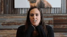 a woman with a nose ring is covering her mouth with her hands