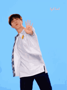 a boy with a heart drawn on his hand stands in front of a blue background