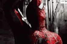 a close up of a person in a spiderman costume standing in a dark room .
