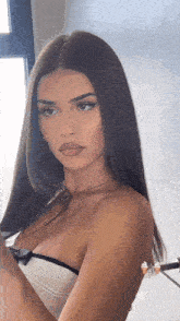 a woman with long hair is wearing a strapless top and looking at the camera