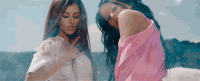 two women are standing next to each other and one is wearing a pink shirt