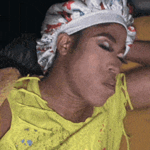 a woman wearing a satin cap and a yellow shirt