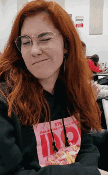 a woman wearing glasses and a hoodie that says 100