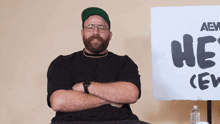 a man with his arms crossed stands in front of a sign that says he 's crew