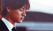 a young man in a suit and tie is looking down .