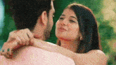 a man and a woman are looking at each other and hugging .