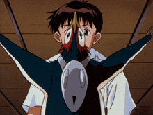 a boy is holding a bird with a red beak in front of his face