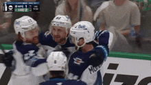 a hockey player wearing a bell helmet is hugging another player