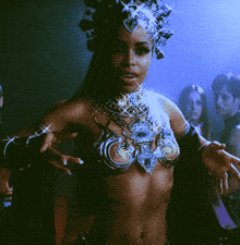 a woman with a crown on her head is wearing a bra and bracelets