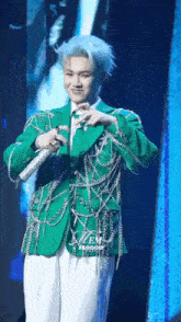 a man with blue hair is wearing a green jacket with chains around it