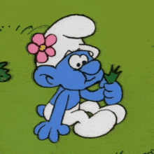 a smurf with a pink flower on his hat is holding a green plant