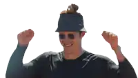 a man wearing a bucket hat and sunglasses holds his arms up in the air