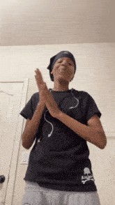 a person wearing a black shirt with a skull and crossbones on it is clapping