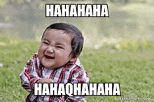 a baby is laughing and making a funny face while sitting on the grass .