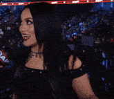 a woman giving a thumbs up in front of a crowd at a wrestling event