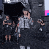 a girl wearing a sweater that says ' tokyo ' on it stands in front of a group of people