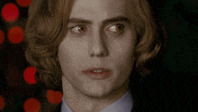 a close up of a man 's face with long hair
