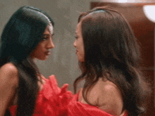 two women are standing next to each other looking at each other .